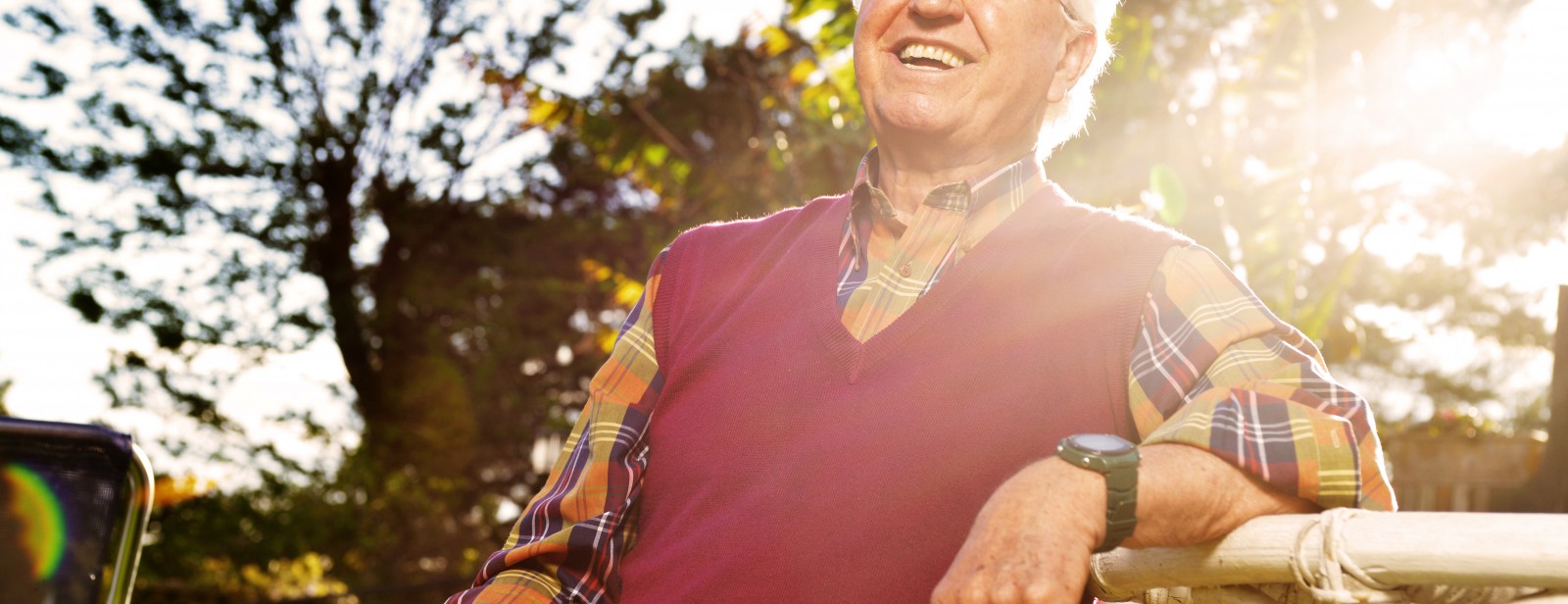 Happy elderly man enjoying outdoor activities in sunny garden, representing positive aging and senior wellness in gerontology