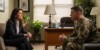 Female military psychologist in professional attire conducting therapy session with male service member in uniform in private counseling office
