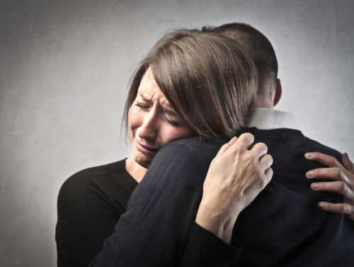United in sorrow | CareersinPsychology.org Woman receiving compassionate support during grief counseling session, demonstrating therapeutic comfort and emotional healing