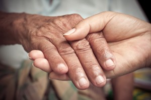 Senior and young holding hands