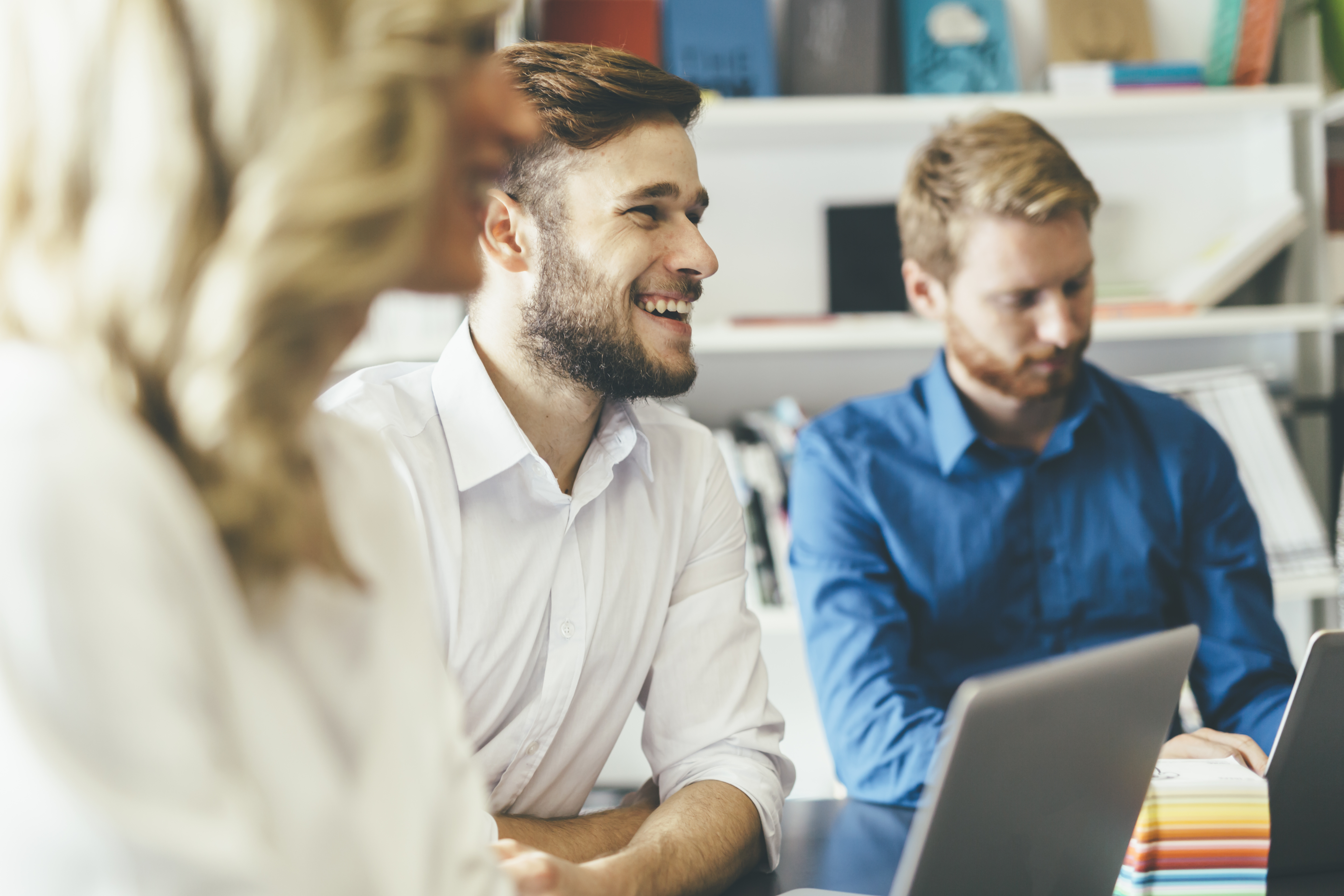 Cheerful coworkers in office | CareersinPsychology.org Environmental psychology professionals collaborating in modern office workspace with natural lighting and ergonomic design