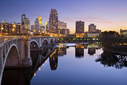 Minneapolis Minnesota skyline at sunset with Stone Arch Bridge over Mississippi River, representing career opportunities for licensed professional counselors in Minnesota